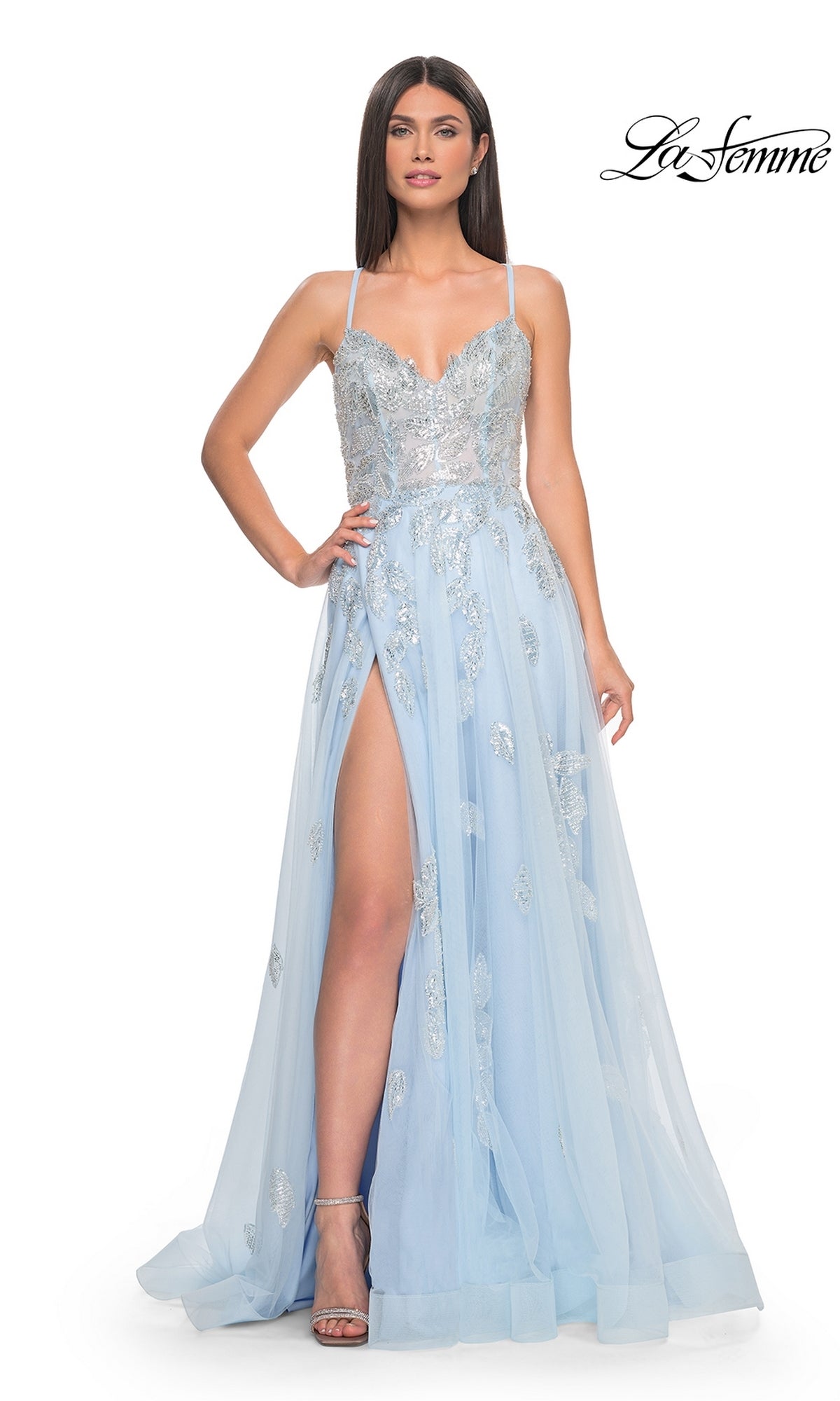 A woman wears the La Femme Sequin-Embroidered Long Prom Dress 32090, a light blue A-line gown with silver sequin embroidery, thin straps, a sweetheart neckline, and a high slit.